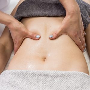 Beautiful young woman enjoying massage in spa salon. Cosmetology concept