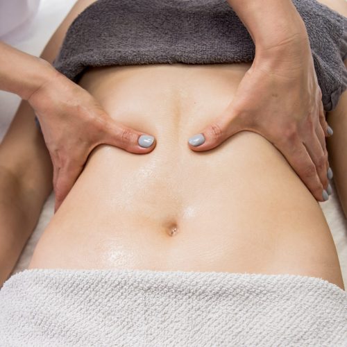 Beautiful young woman enjoying massage in spa salon. Cosmetology concept